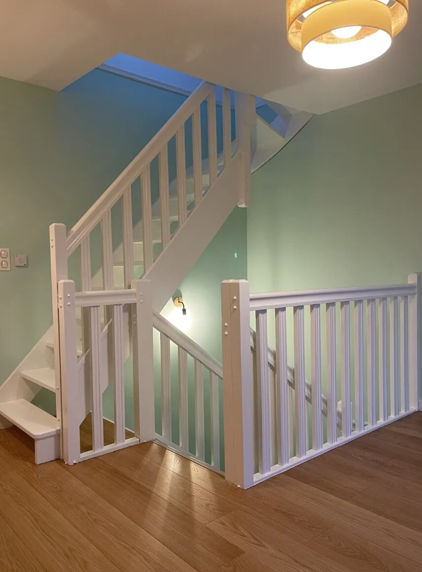 Escalier blanc et mur vert pastel